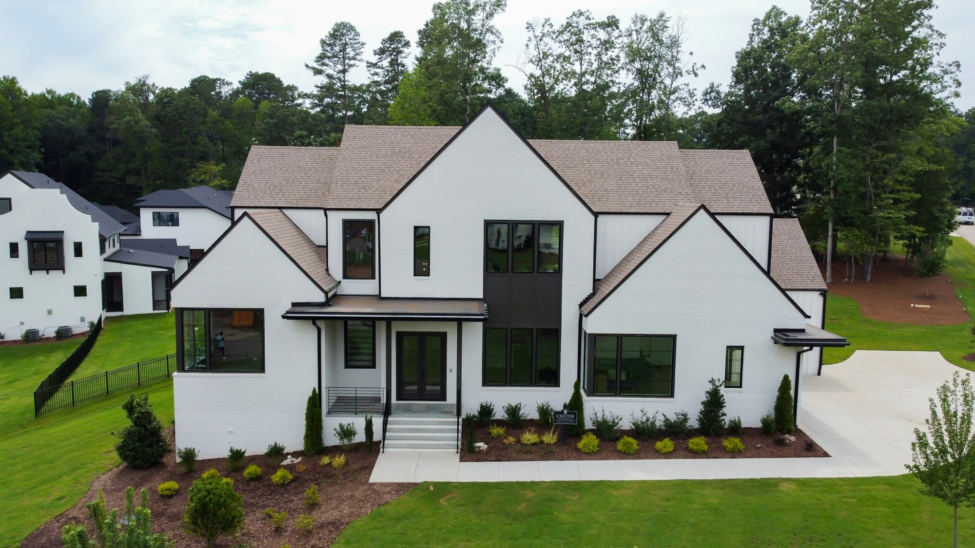 White modern farmhouse with a manicured lawn