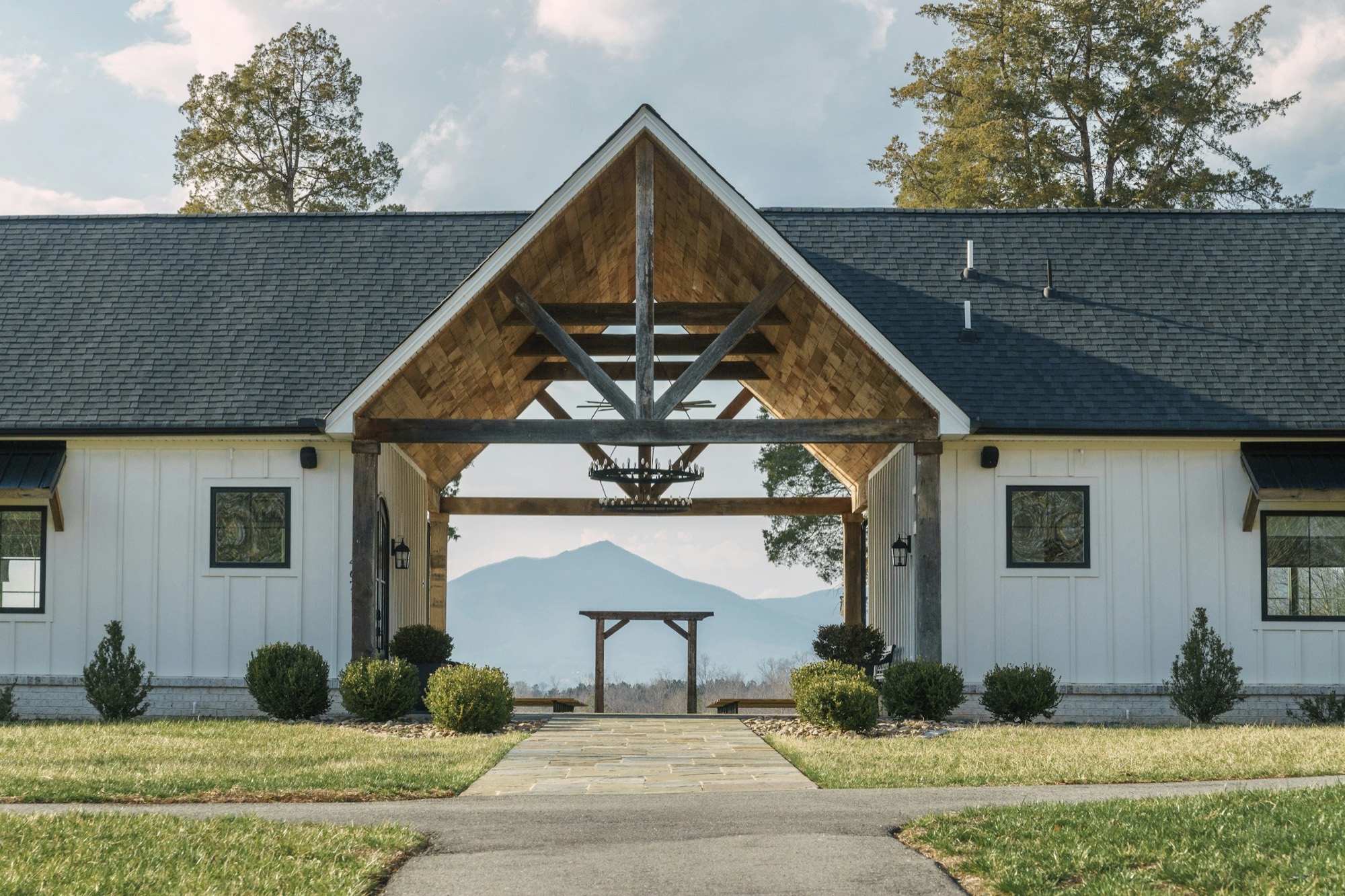 Modern farmhouse with a mountain view through a timber archway